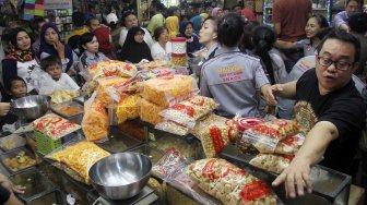 Warga mengantre membeli kue kering di pasar Jatinegara, Jakarta, Sabtu (1/6).[Suara.com/Oke Atmaja]