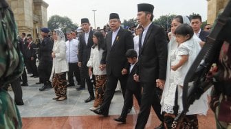 Presiden RI keenam Susilo Bambang Yudhoyono didampingi anak saat mengantar jenazah di makam Ibu Ani Yudhoyono, Taman Makam Pahlawan Kalibata, Jakarta, Minggu (2/6). [Suara.com/Muhaimin A Untung]