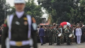 Prajurit TNI melepaskan tembakan ke udara saat prosesi pemakaman istri presiden ke-6 RI Susilo Bambang Yudhoyono (SBY), Ani Yudhoyono di TMP Kalibata, Jakarta, Minggu (2/6). [Suara.com/Muhaimin A Untung]