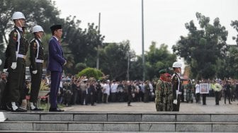 Presiden Joko Widodo menyaksikan prajurit TNI melepaskan tembakan ke udara saat prosesi pemakaman istri presiden ke-6 RI Susilo Bambang Yudhoyono (SBY), Ani Yudhoyono di TMP Kalibata, Jakarta, Minggu (2/6). [Suara.com/Muhaimin A Untung]