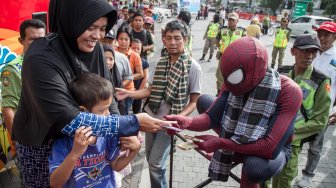 Panitia dari Keluarga Alumni Universitas Gadjah Mada (Kagama) berkostum superhero Spiderman membagikan sarung dan uang fitrah kepada warga pada kegiatan Berbagi Sarung Untuk Sahabat di Balaikota Solo, Jawa Tengah, Senin (3/6). [ANTARA FOTO/Mohammad Ayudha]