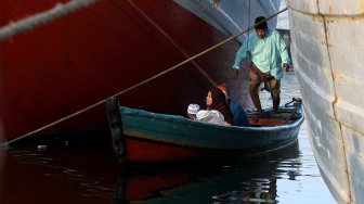 Umat muslim melaksanakan Sholat Idul Fitri di kawasan pelabuhan Sunda Kelapa, Rabu (5/6). [Suara.com/Arief Hermawan P]