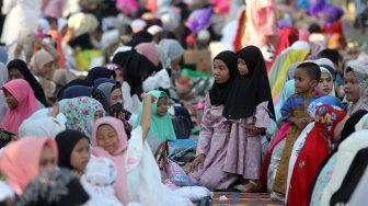 Umat muslim melaksanakan Sholat Idul Fitri di kawasan pelabuhan Sunda Kelapa, Rabu (5/6). [Suara.com/Arief Hermawan P]