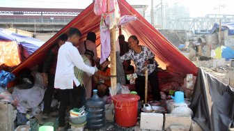 Warga Kampung Bandan beraktifitas di sekitar bangunan sisa kebakaran yang dijadikan pengungsian, Pademangan, Jakarta, Rabu (5/6). [Suara.com/Arief Hermawan P]