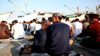 Umat muslim melaksanakan Sholat Idul Fitri di kawasan pelabuhan Sunda Kelapa, Rabu (5/6). [Suara.com/Arief Hermawan P]