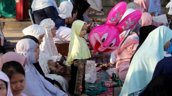 Umat muslim melaksanakan Sholat Idul Fitri di kawasan pelabuhan Sunda Kelapa, Rabu (5/6). [Suara.com/Arief Hermawan P]