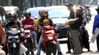 Pedagang menawarkan tikar kepada warga yang melintas di Jalan RM Harsono, Jakarta Selatan, Kamis (6/6).  [Suara.com/Arief Hermawan P]