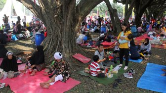 Pengunjung menikmati suasana di kawasan wisata Taman Mini Indonesia Indah (TMII), Jakarta, Jumat (7/6). [Suara.com/Arief Hermawan P]
