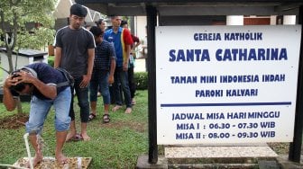 Umat muslim mengambil air wudhu di halaman Gereja Katolik Santa Catharina di kawasan Taman Mini Indonesia Indah (TMII), Jakarta, Jumat (7/6). [Suara.com/Arief Hermawan P]