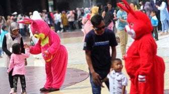 Pengunjung menikmati suasana di kawasan wisata Taman Mini Indonesia Indah (TMII), Jakarta, Jumat (7/6). [Suara.com/Arief Hermawan P]
