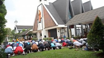 Umat muslim melaksanakan Salat Jumat berjamaah di halaman Gereja Katolik Santa Catharina di kawasan Taman Mini Indonesia Indah (TMII), Jakarta, Jumat (7/6). [Suara.com/Arief Hermawan P]