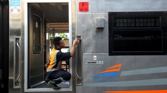 Petugas membersihkan gerbong Kereta Api di Stasiun Pasar Senen, Jakarta, Minggu (9/6). [Suara.com/Arief Hermawan P]