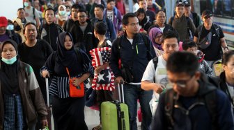 Penumpang kereta api tiba di Stasiun Pasar Senen, Jakarta, Minggu (9/6). [Suara.com/Arief Hermawan P]