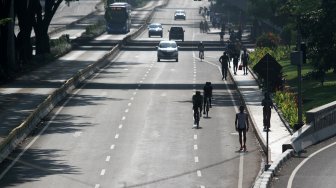 Warga berolahraga di Jalan Jenderal Sudirman, Jakarta, Minggu (9/6). [Suara.com/Arief Hermawan P]