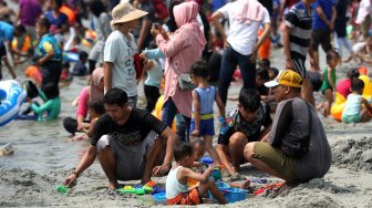 Pengunjung memadati Pantai Karnaval Ancol, Jakarta, Minggu (9/6). [Suara.com/Arief Hermawan P]
