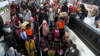 Penumpang kereta api tiba di Stasiun Pasar Senen, Jakarta, Minggu (9/6). [Suara.com/Arief Hermawan P]