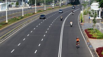 Warga berolahraga di Jalan Jenderal Sudirman, Jakarta, Minggu (9/6). [Suara.com/Arief Hermawan P]