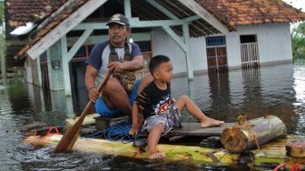 Warga berada di atas perahu menerobos banjir sejak dua pekan lalu di Desa Laloika, Kecamatan Pondidaha, Konawe, Sulawesi Tenggara, Minggu (9/6). [ANTARA FOTO/Jojon]