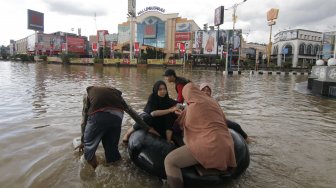 Sejumlah warga duduk di atas ban besar yang didorong oleh relawan saat melintasi kawasan Simpang Lembuswana, Samarinda, Kalimantan Timur, Senin (10/6). ANTARA FOTO/Kirana Larasati