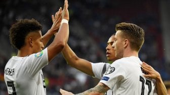 Pemain depan Jerman Marco Reus merayakan golnya setelah mencetak gol pembuka dengan rekan satu timnya selama pertandingan sepak bola Grup C kualifikasi Euro 2020 Jerman melawan Estonia di Opel Arena, Mainz, Jerman, Rabu (12/6). dini hari WIB. [Ina Fassbender / AFP]