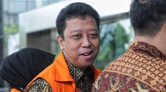 Eks Ketua Umum PPP Romahurmuziy menutupi tangan terborgol dengan buku saat menjalani pemeriksaan di Gedung KPK, Jakarta, Rabu (12/6). [Suara.com/Muhaimin A Untung]