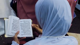 Sejumlah emak-emak membaca Alquran di sela sidang sengketa Pilpres yang digelar di Mahkamah Konstitusi, Jakarta, Jumat (14/6). [Suara.com/Oke Atmaja]