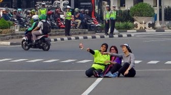 Warga berselfie di Jalan Merdeka Barat, Jakarta, Jumat (14/6). [Suara.com/Oke Atmaja]