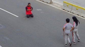 Warga berselfie di Jalan Merdeka Barat, Jakarta, Jumat (14/6). [Suara.com/Oke Atmaja]