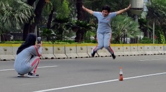 Warga berselfie di Jalan Merdeka Barat, Jakarta, Jumat (14/6). [Suara.com/Oke Atmaja]