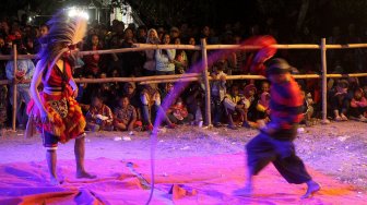 Warga menyaksikan Kesenian Jaranan di Dusun Paras, Desa Turipinggir, Kecamatan Megaluh, Kabupaten Jombang, Jumat (14/6). [Suara.com/Arief Hermawan P]