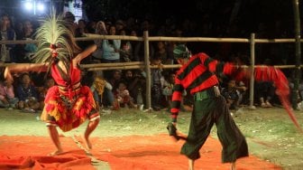 Warga menyaksikan Kesenian Jaranan di Dusun Paras, Desa Turipinggir, Kecamatan Megaluh, Kabupaten Jombang, Jumat (14/6). [Suara.com/Arief Hermawan P]