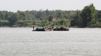 Sejumlah warga berada di atas perahu saat menambang pasir di Sungai Brantas, Kecamatan Megaluh, Kabupaten Jombang, Jawa Timur, Minggu (16/6). [Suara.com/Arief Hermawan P]