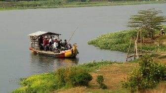 Sejumlah warga menyeberangi Sungai Brantas menggunakan jasa perahu tambang di kawasan Megaluh, Kabupaten Jombang, Jawa Timur, Minggu (16/6). [Suara.com/Arief Hermawan P]