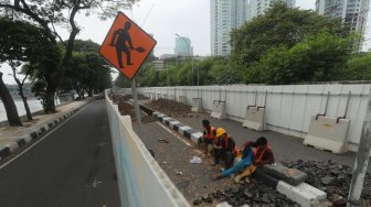 Sejumlah pekerja beraktifitas di samping proyek kereta Light Rail Transit (LRT) di Jalan Setiabudi Tengah, Jakarta Pusat, Senin (17/6). [Suara.com/Muhaimin A Untung]