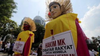 Sejumlah massa aksi membawa ondel-ondel aksi di depan Patung kuda, Jakarta, Selasa (18/6).[Suara.com/Muhaimin A Untung]
