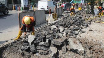 Pekerja menyelesaikan penataan Trotoar Cikini dan Kramat di kawasan Cikini, Jakarta Pusat, Rabu (19/6). [Suara.com/Muhaimin A Untung]