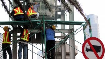 Pekerja menyelesaikan pembongkaran lift Jembatan Penyeberangan Orang (JPO) Tosari di kawasan Bundaran HI, Jakarta, Rabu (19/6). [Suara.com/Arief Hermawan P]