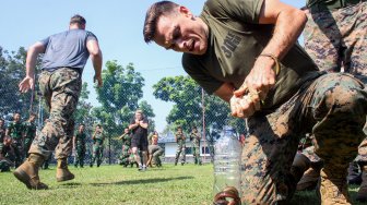 Prajurit Marinir Amerika Serikat dari United States Marine Corps/United States Marine Pacific (US MARFORPAC) mengikuti lomba memasukkan belut kedalam botol di lapangan Brigif 2 Marinir Gedangan, Sidoarjo, Jawa Timur, Jumat (21/6). [ANTARA FOTO/Umarul Faruq]