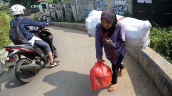 Sejumlah perempuan memanggul barang rongsokan di kawasan Beji, Kota Depok, Jawa Barat, Sabtu (22/6). [Suara.com/Arief Hermawan P]