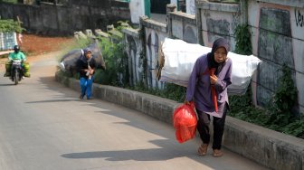 Sejumlah perempuan memanggul barang rongsokan di kawasan Beji, Kota Depok, Jawa Barat, Sabtu (22/6). [Suara.com/Arief Hermawan P]