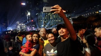 Ribuan warga memadati kawasan Bundaran Hotel Indonesia (HI) saat gelaran Jakarta Night Festival di Jakarta, Sabtu (22/6). [Suara.com/Arief Hermawan P]