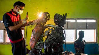 Siswa menyelesaikan pembuatan robot polisi berbahan onderdil motor bekas di SMK Karya Utama, Warung Bambu, Karawang, Jawa Barat, Senin (24/6). ANTARA FOTO/M Ibnu Chazar