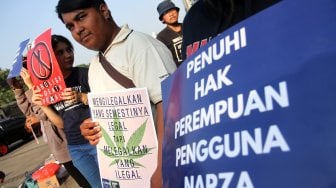 Sejumlah aktivis yang berasal dari organisasi Lembaga Bantuan Hukum Masyarakat (LBHM) menggelar aksi di kawasan Monas, Jakarta, Selasa (25/6). [Suara.com/Arief Hermawan P]