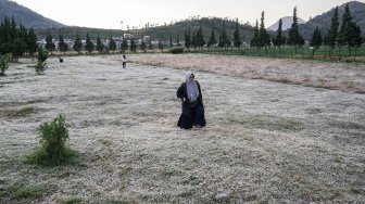 Wisatawan menikmati embun beku yang muncul akibat penurunan suhu hingga minus tujuh derajat celcius di kompleks Candi Arjuna, di dataran tinggi Dieng, Banjarnegara, Jawa Tengah, Selasa (25/6). ANTARA FOTO/Idhad Zakaria