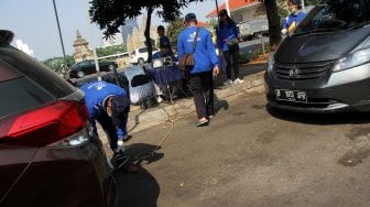 Petugas melakukan pemerikasaan emisi gas buang kendaraan di halaman parkir Taman Makam Pahlawan (TMP) Kalibata, Jakarta, Selasa (25/6). [Suara.com/Arief hermawan P]