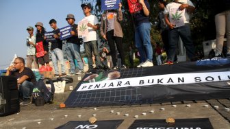 Sejumlah aktivis yang berasal dari organisasi Lembaga Bantuan Hukum Masyarakat (LBHM) menggelar aksi di kawasan Monas, Jakarta, Selasa (25/6). [Suara.com/Arief Hermawan P]