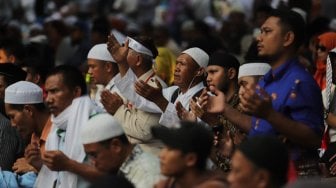 Sejumlah peserta aksi melakukan salat Ashar berjamaah di kawasan Gedung Mahkamah Konstitusi, Jakarta, Kamis (27/6). [Suara.com/Muhaimin A Untung]
