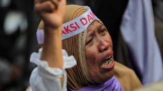 Emak-emak peserta aksi menangis saat mengikuti aksi di kawasan Mahkamah Konstitusi, Jakarta, Kamis (27/6). [Suara.com/Muhaimin A Untung]