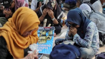 Emak-emak peserta aksi menangis saat mengikuti aksi di kawasan Mahkamah Konstitusi, Jakarta, Kamis (27/6). [Suara.com/Muhaimin A Untung]