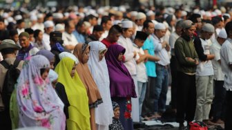 Sejumlah peserta aksi melakukan salat Ashar berjamaah di kawasan Gedung Mahkamah Konstitusi, Jakarta, Kamis (27/6). [Suara.com/Muhaimin A Untung]
